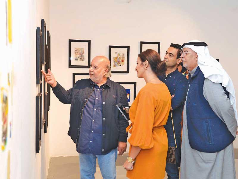 العوضي شارحاً محتوى لوحاته للضيوف