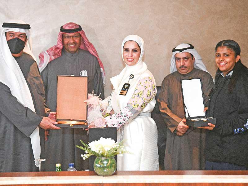 وزير التربية د. علي المضف مكرماً الطالبة العنزي وتبدو المديرة أسماء اليحيىt (تصوير نوفل إبراهيم)