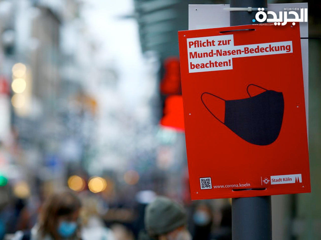 لافتة كتب عليها «احترم الالتزام بتغطية فمك وأنفك» في شارع التسوق بكولونيا