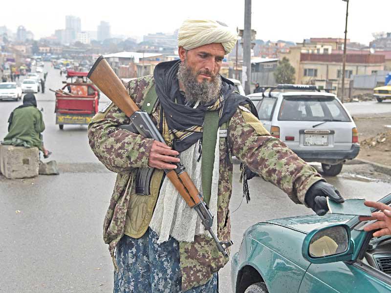 أحد عناصر حركة طالبان يتفحص أوراق الثبوتية لأحد المواطنين في العاصمة الأفغانية كابول