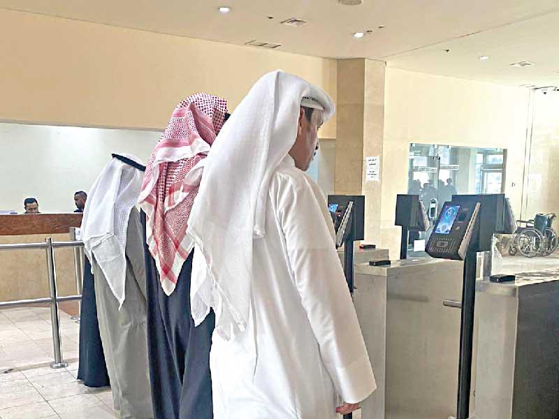 موظفون أمام أجهزة بصمة الوجه