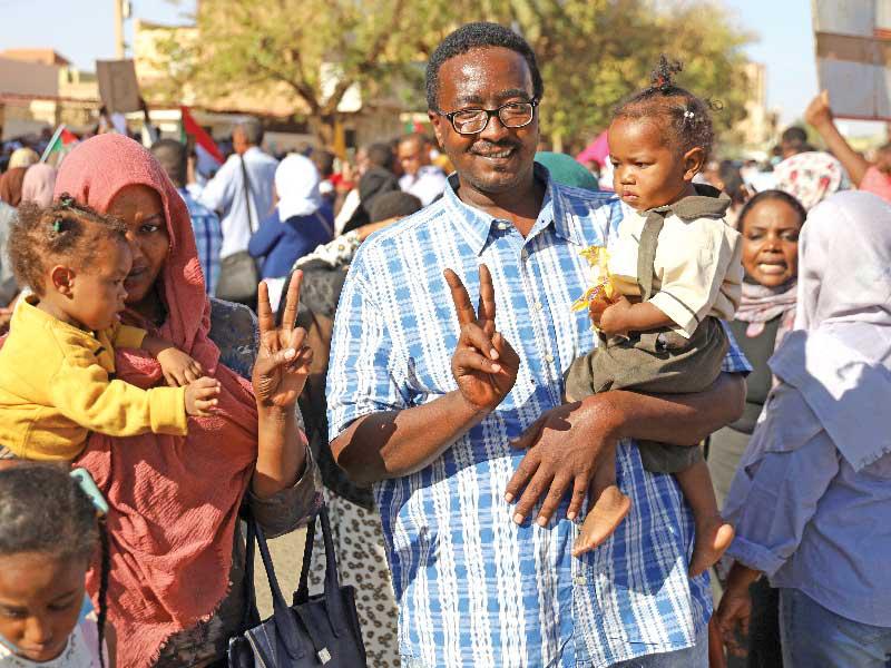 أسرة سودانية في وقفة احتجاجية على العنف ضد النساء بأم درمان (رويترز)