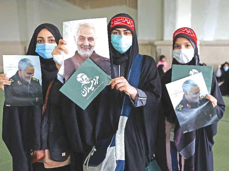 إيرانيات يحملن صوراً لسليماني خلال تجمع بذكرى مقتله في طهران أمس (رويترز)