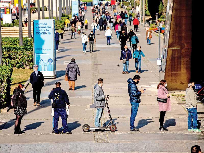 إسبان ينتظرون أمام مركز صحي للحصول على التطعيم في برشلونة امس (د ب أ)