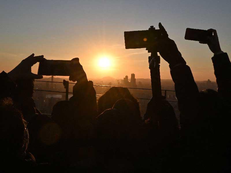 يستمتع الناس بآخر غروب شمس في العام على منصة مشاهدة في برج نامسان في سيول