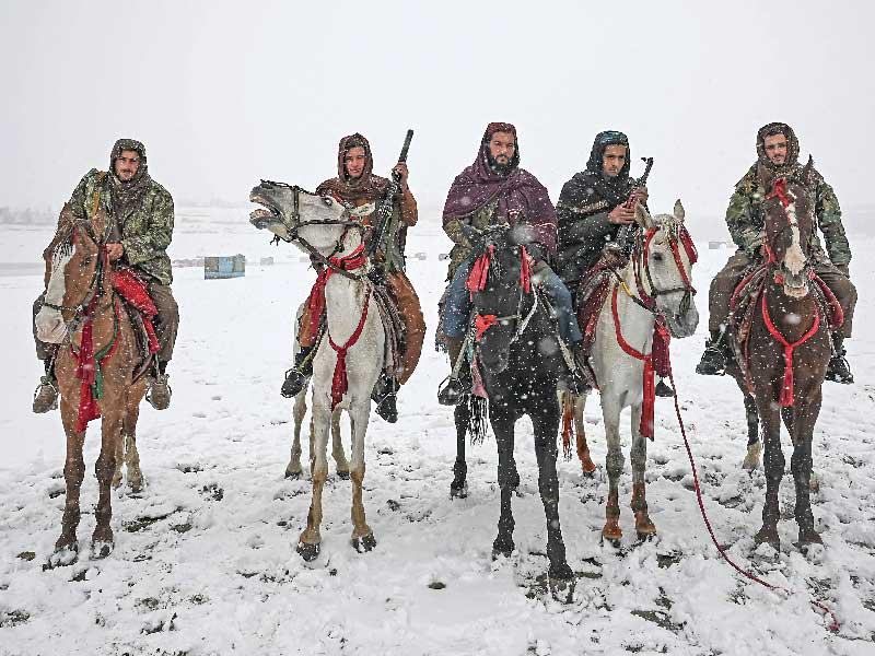 مقاتلو طالبان يقفون لالتقاط صور وهم يركبون خيولا خلال تساقط الثلوج