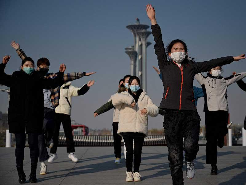 صينيون يؤدون تمارين رياضية في القرية الأولمبية ببكينt (أ ف ب) 