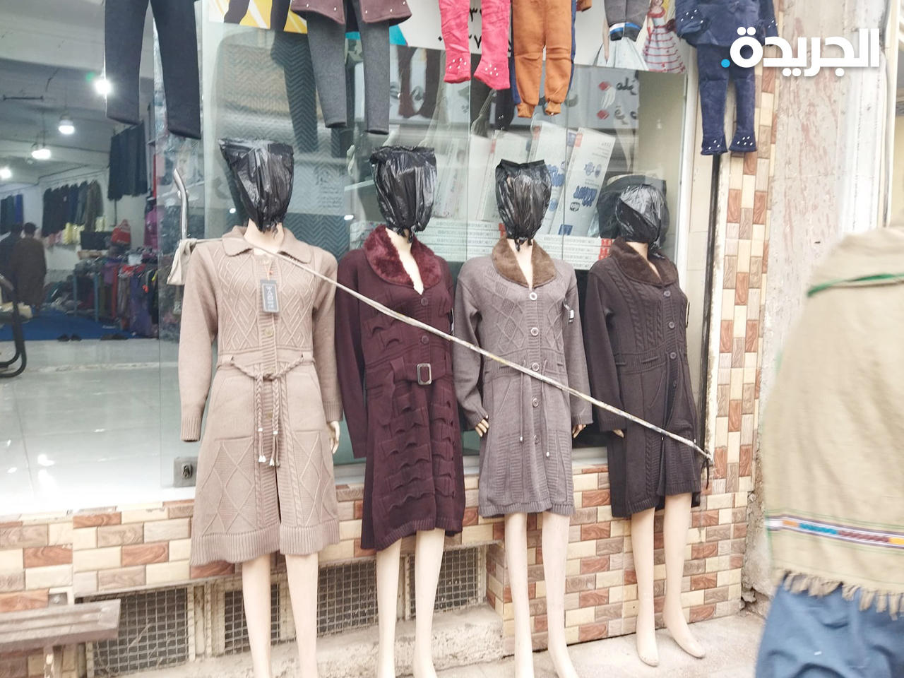 تغطية رؤس دمى العرض البلاستيكية بأكياس سوداء