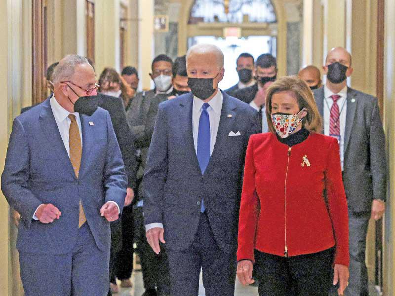 بايدن متوسطاً زعيمي الأكثرية الديموقراطية  في مجلسي النواب والشيوخ قبل إلقاء خطابه في الكابيتول أمس (رويترز)