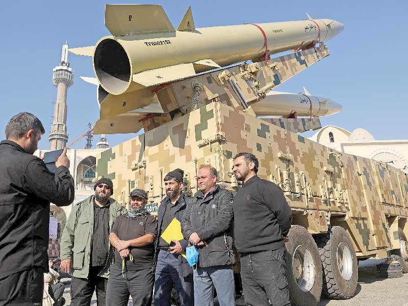 التقاط صورة لإيرانيين قبل أيام أمام مجسم لصاروخ (رويترز)