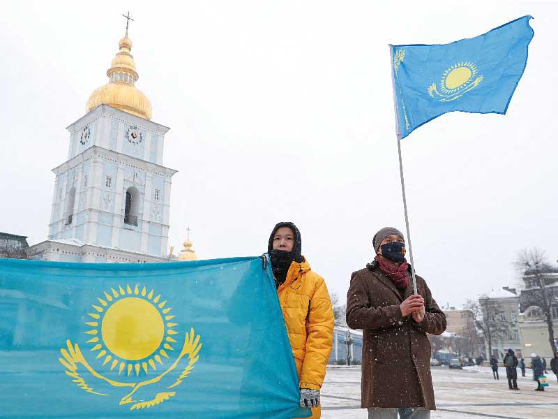 علم كازاخستان مرفوعاً في وسط كييف خلال تجمع مؤيد للمحتجين الكازاخستانيين أمس t(رويترز)
