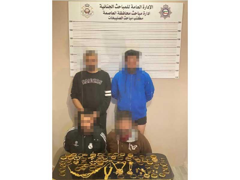 المتهمون وأمامهم المسروقات