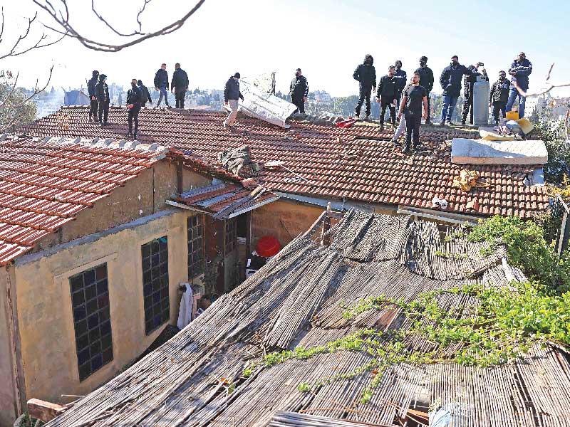 مقدسيون يعتصمون على سطح منزلهم المهدد بالإخلاء في الشيخ جراح أمس (أ ف ب) 