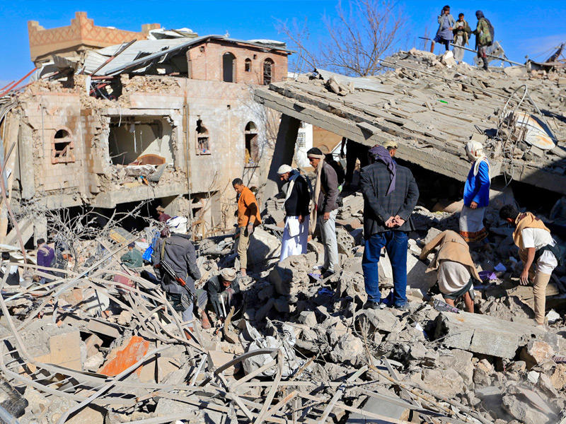 يمنيون بموقع استهدفته مقاتلات «التحالف» في صنعاء أمس (أ ف ب)