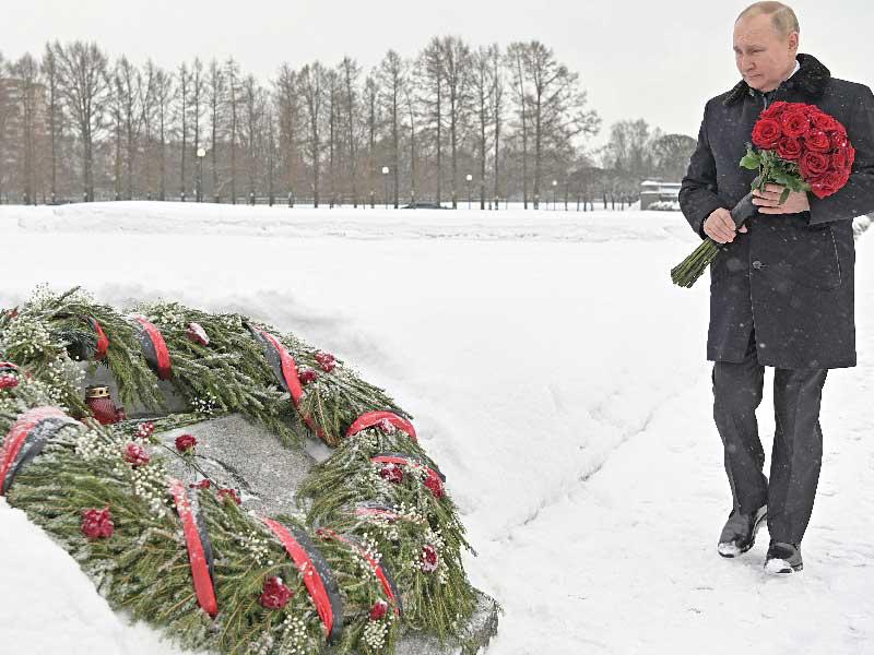 بوتين يضع وروداً على مقبرة تذكارية في بطرسبورغ، في ذكرى فك الحصار النازي عنها عام 1944. وفقد بوتين شقيقه، الذي توفي صغيرا أثناء حصار لينينغراد الاسطوري                          (رويترز) 
