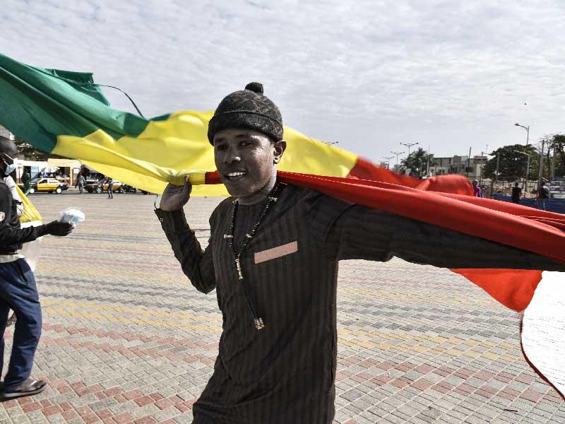 متظاهر يحمل علم مالي خلال مظاهرة لدعم مالي