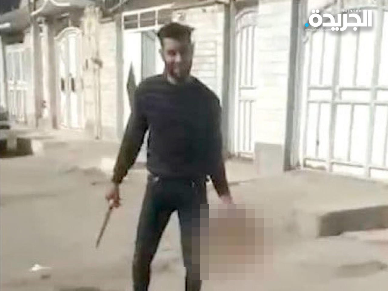 القاتل حاملاً رأس الضحية بيد والسكين بيد أخرى