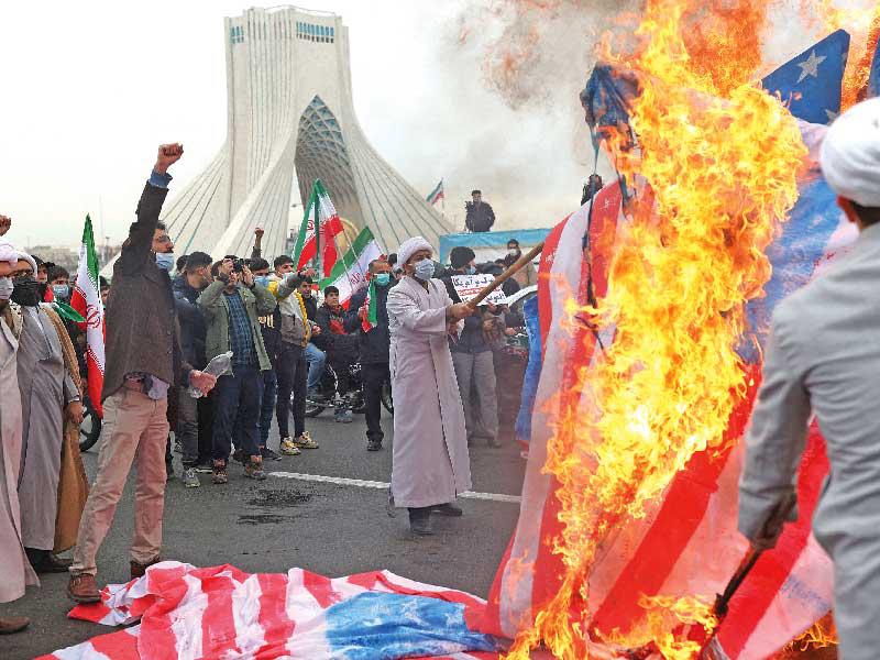 إيرانيون يشعلون النار في العلم الأميركي خلال احتفالات بالذكرى الـ43 للثورة في طهران أمس الأولt (رويترز)