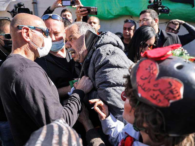 رجل فلسطيني يواجه شرطي إسرائيلي بملابس مدنية في حي الشيخ جراح بالقدس الشرقية