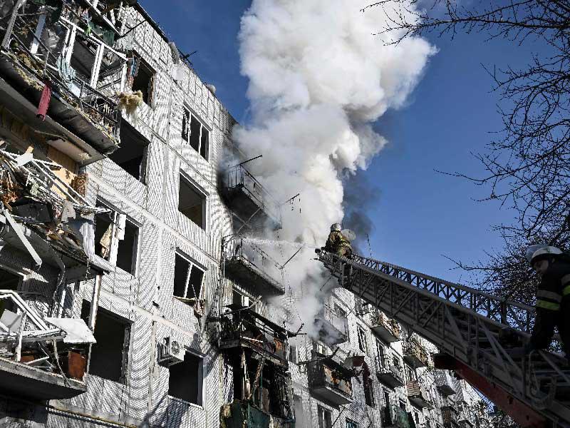 عناصر إطفاء يحاولون إخماد حريق في عمارة بمدينة شوغييف بعد إصابتها بقصف روسي اليوم (أ ف ب)