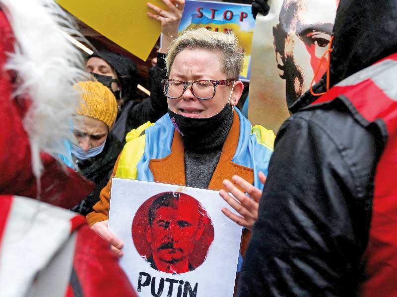 بوتين وستالين وجهان لعملة واحدة على لافتة لمتظاهرة متضامنة مع كييف في إسطنبول (رويترز) 