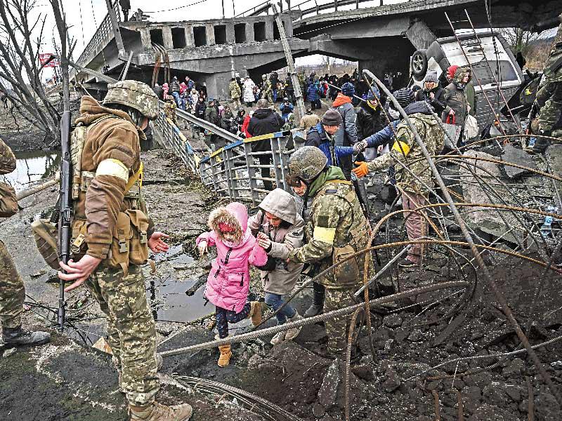 مدنيون يحاولون عبور جسر مدمّر في مدينة إيربين قرب كييف أمس (ا ف ب)n