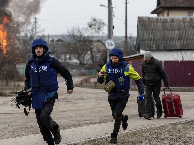 صحافيان يركضان بعد سقوط قذيفة قربهما في إربين  (رويترز)n