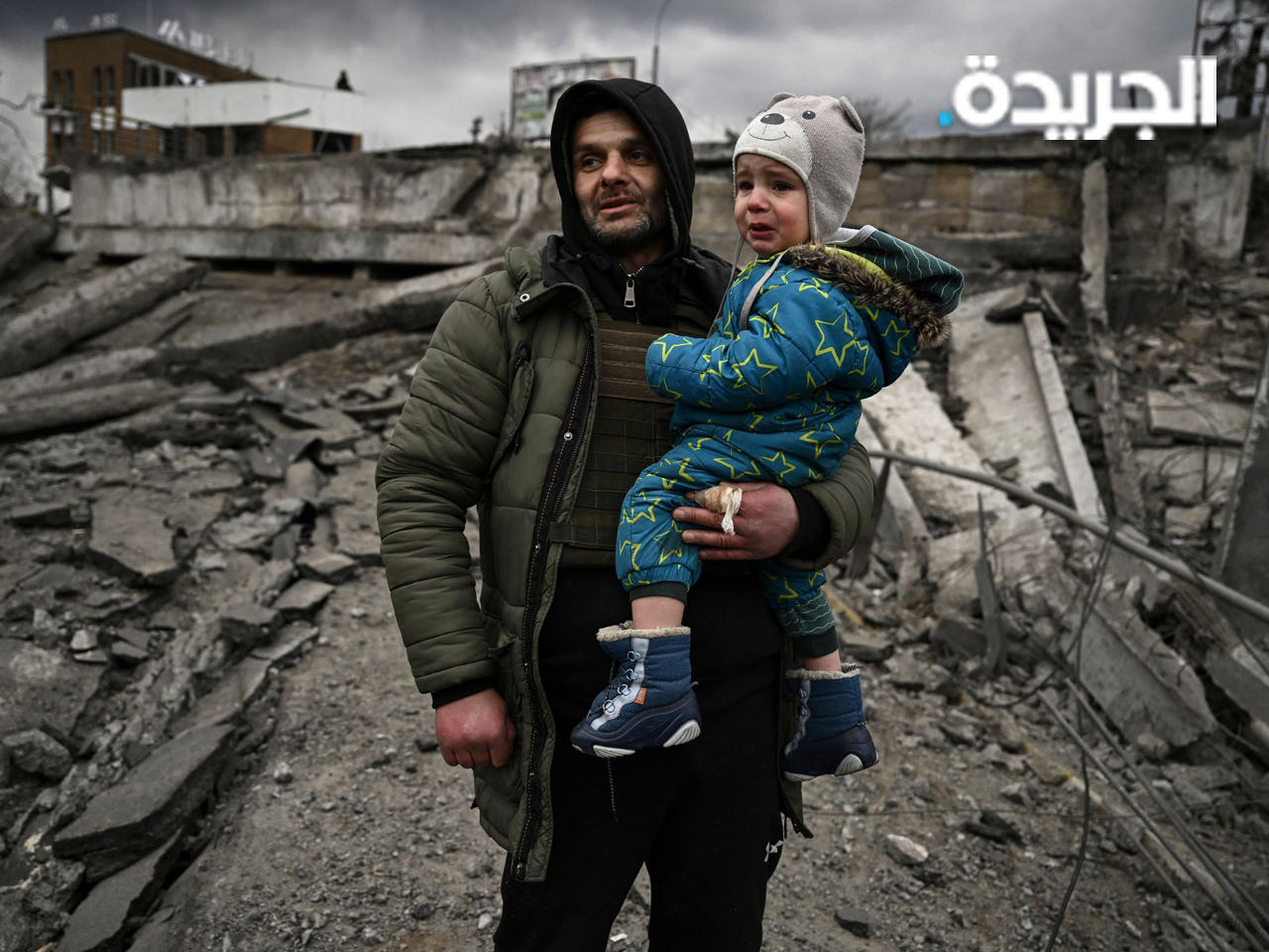 رجل يحمل طفلًا أثناء فراره من مدينة إيربين غربي كييف