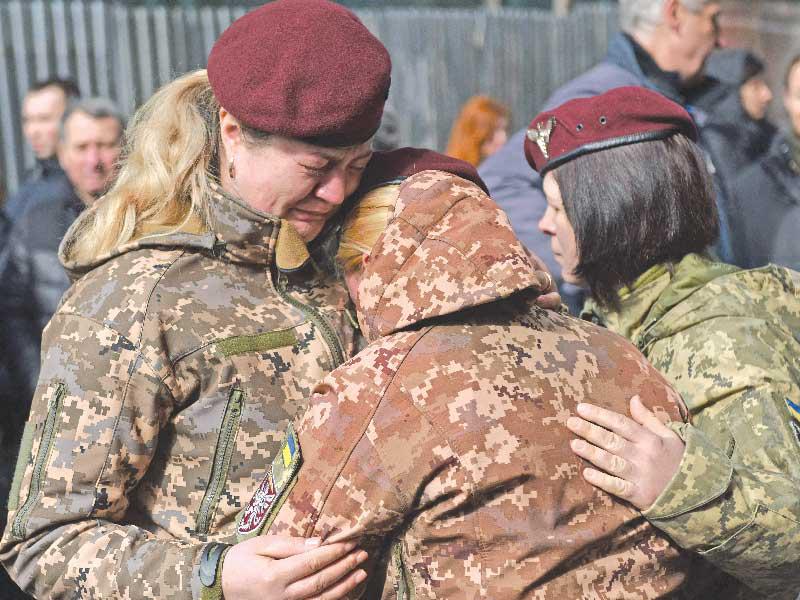 مجندات أوكرانيات يبكين خلال تشييع 3 من رفاقهن الجنود في مدينة لفيف أمس (أ ف ب)