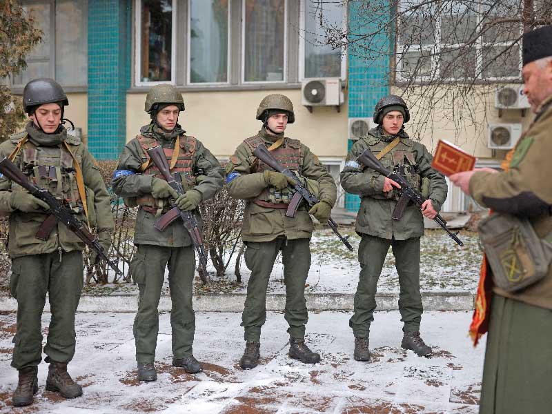 كاهن أوكراني يصلّي مع مجموعة من الجنود في كييف أمس  (رويترز)