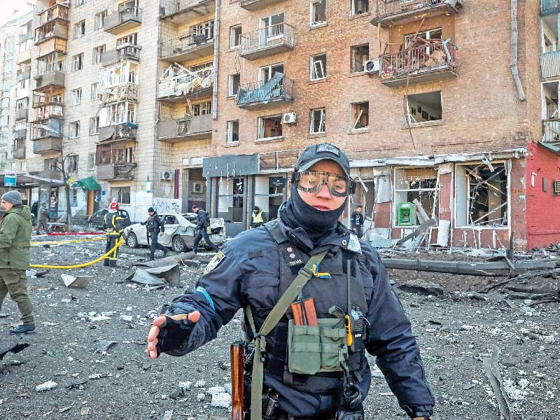 شرطي أوكراني في موقع تعرض لقصف روسي في كييف أمس (رويترز)