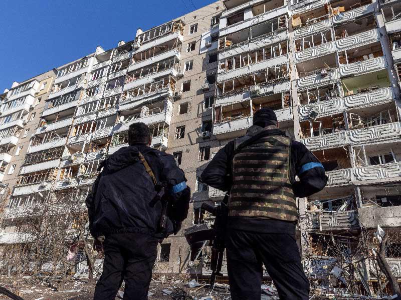 جنديان أوكرانيان يعاينان الدمار الذي لحق بعمارات سكنية بفعل القصف الروسي في كييف أمس (رويترز)