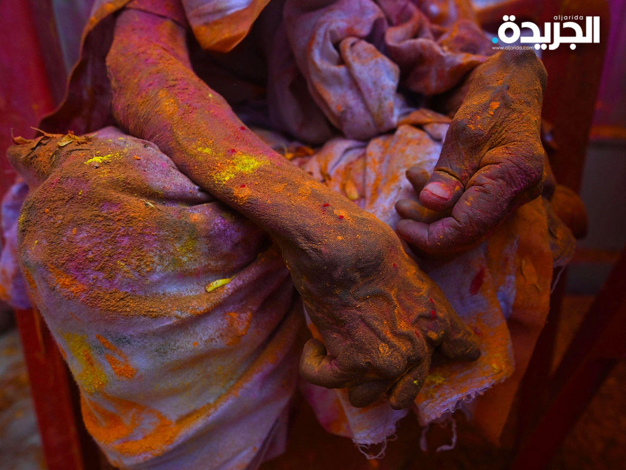 أرملة ملطخة بألوان تجلس في أحد المعابد أثناء مشاركتها في احتفالات هولي