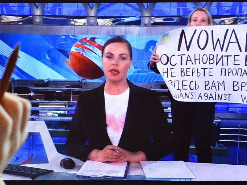 أوفسيانيكوفا لحظة اقتحامها ستوديو الأخبار ورفعها لافتة الاحتجاج (أ ف ب)n