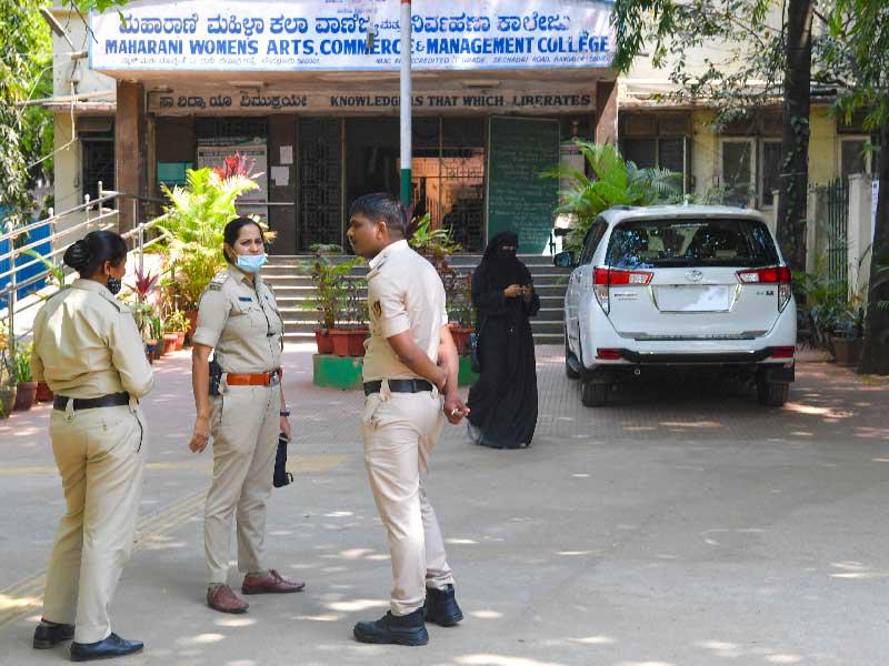 هندية ترتدي الحجاب تمر امام عناصر من الشرطة يحرسون مدرسة في بنغالور (أ ف ب)