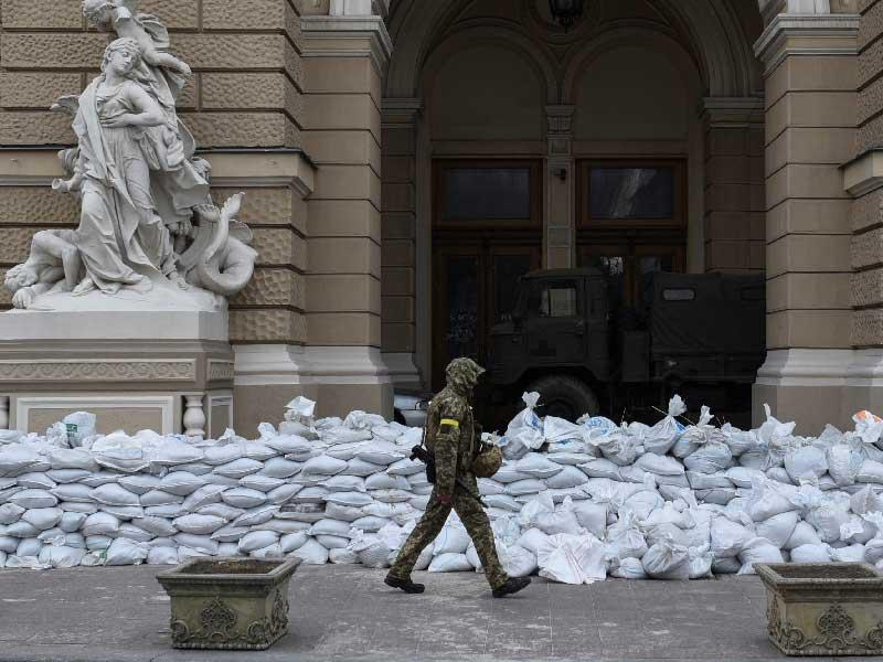 جندي أوكراني يمرّ أمام متاريس موضوعة على مدخل مسرح أوديسا الأكاديمي الوطني للأوبرا والباليه (رويترز)n