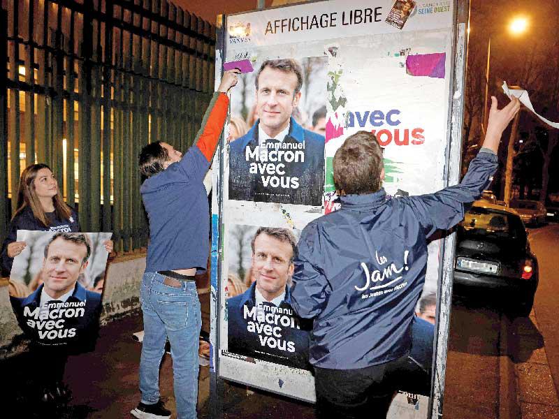 مناصرون لماكرون يلصقون صوره في شوارع فانف (أ ف ب)