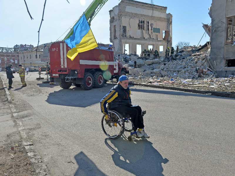 أوكراني على كرسي مدولب وسط الدمار في خاركيف شمال شرق أوكرانيا (أ ف ب) 