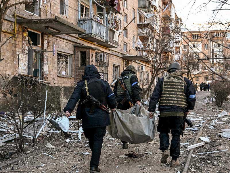 عناصر من الشرطة الأوكرانية تحمل جثة في وسط كييف (أ ف ب)