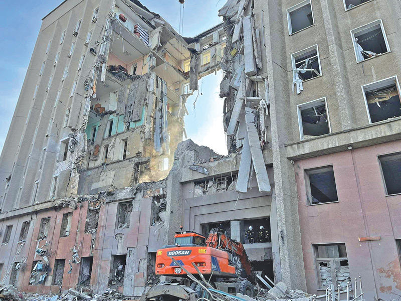 رجال إنقاذ فوق أنقاض مبنى حكومي في ميكولايف دمّره القصف الروسي  (أ ف ب)