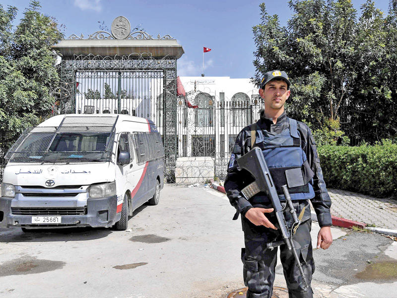 شرطي أمام مقر البرلمان المغلق في العاصمة التونسية أمس (أ ف ب)