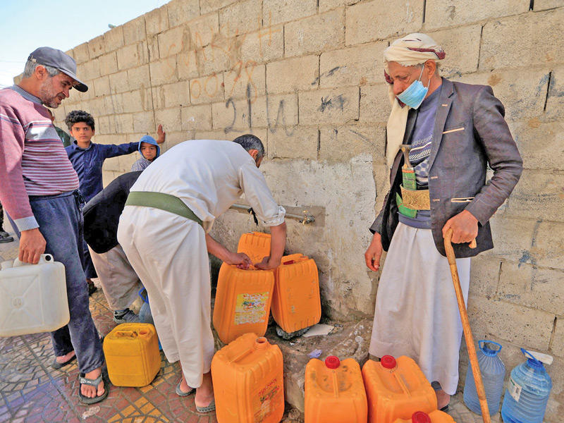 يمنيون في صنعاء ينتظرون لتعبئة المياه (أ ف ب) 