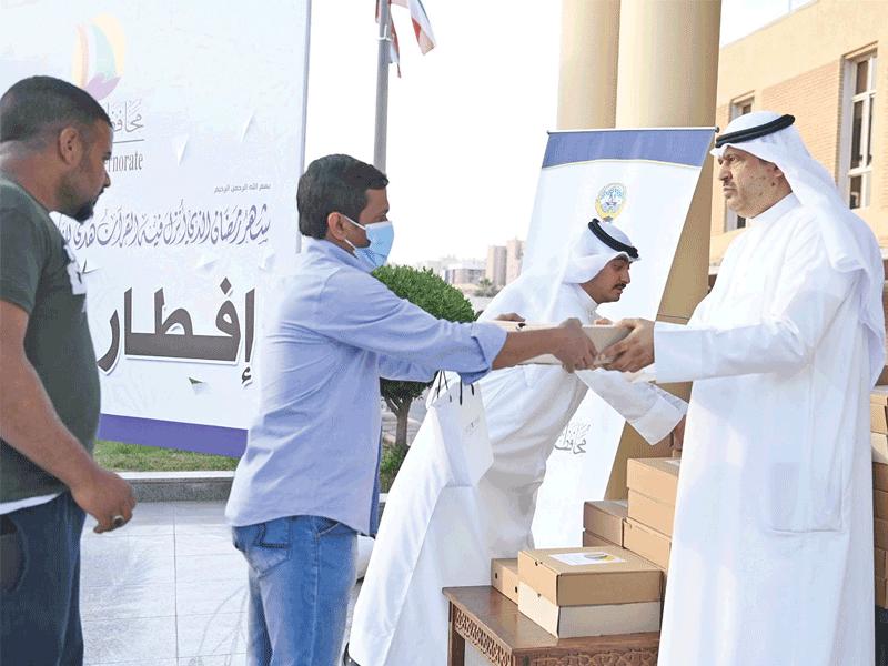 محافظ حولي علي الأصفر خلال توزيع الوجبات