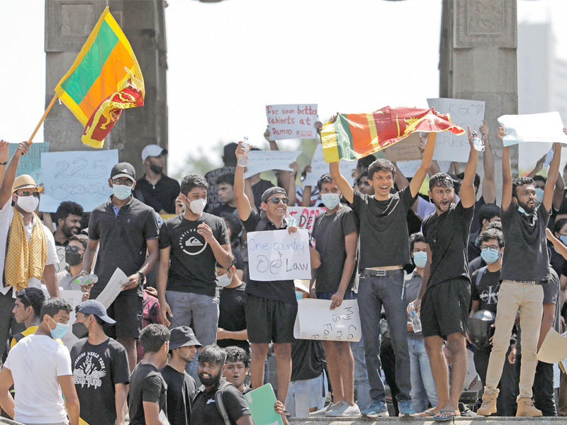 المتظاهرون يطالبون عائلة راجاباكسا بالتنحي في ساحة الاستقلال بكولومبو أمس (رويترز)