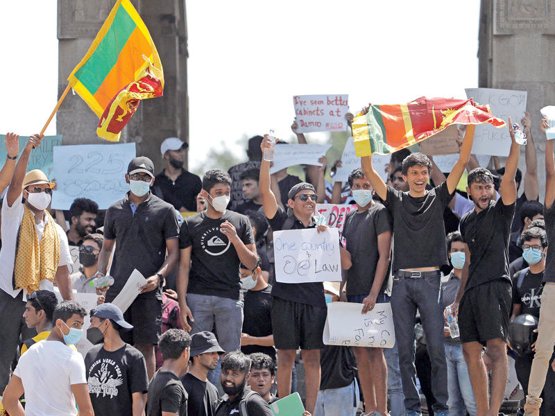 المتظاهرون يطالبون عائلة راجاباكسا بالتنحي في ساحة الاستقلال بكولومبو أمس (رويترز)