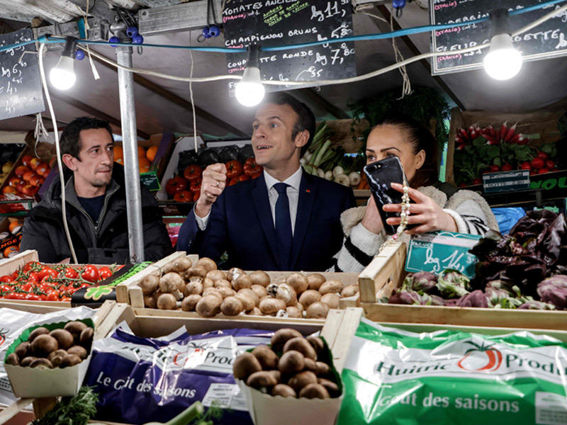 ماكرون يزور سوقاً للخضراوات في نويي سور سين قرب باريس امس الأول (أ ف ب ) 