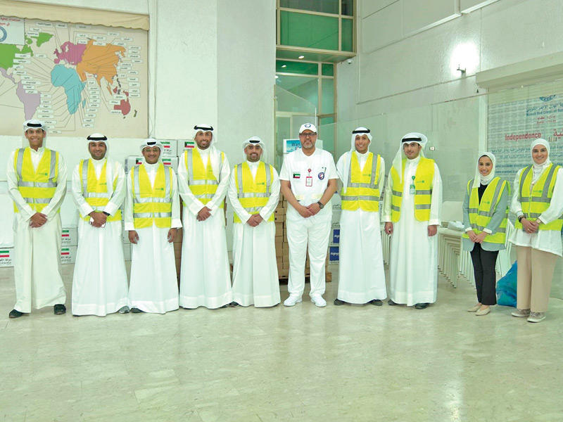 فريق «بيتك» التطوعي ومسؤول من جمعية الهلال الأحمر الكويتي 