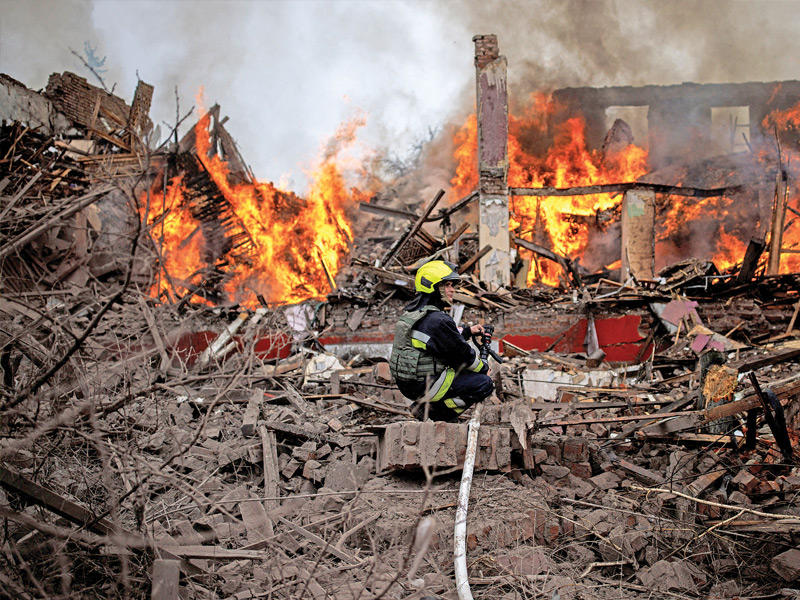  رجال إطفاء يحاولون إخماد حريق سبّبه صاروخ روسي في خاركييف (رويترز)