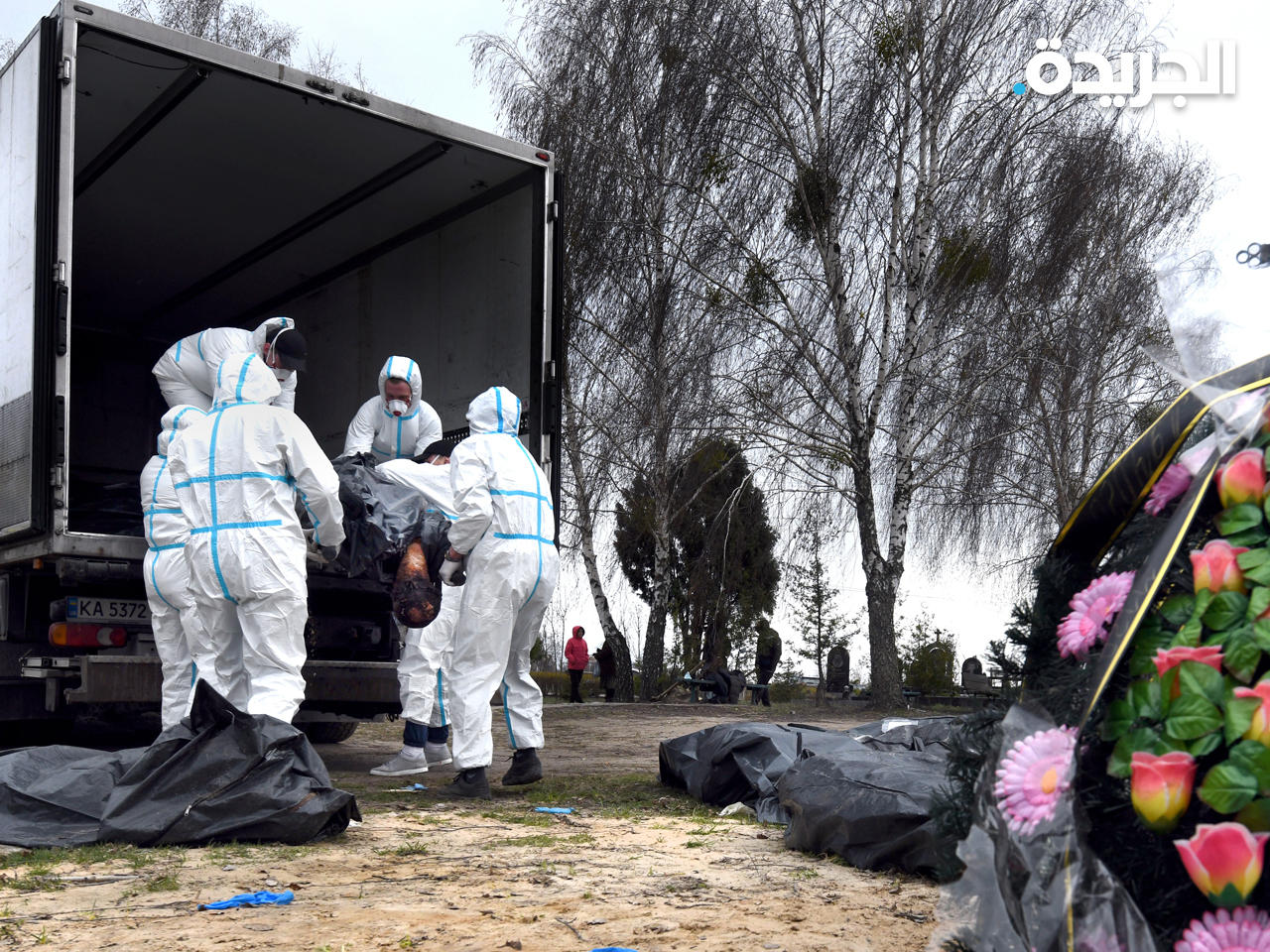 عمال ينقلون جثث مدنيين قتلوا في بوتشا