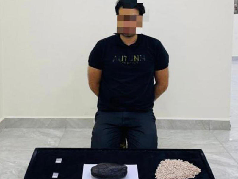 المتهم وأمامه المخدرات